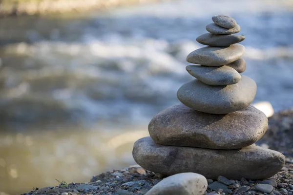 balancing of round stones, the construction of round stones on the rocky river Bank