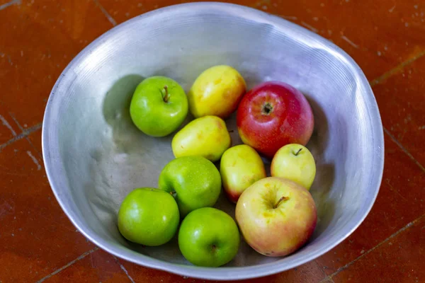 homemade apples from the garden in an enamel basin on the floor. your garden and harvest the apples. organic apples