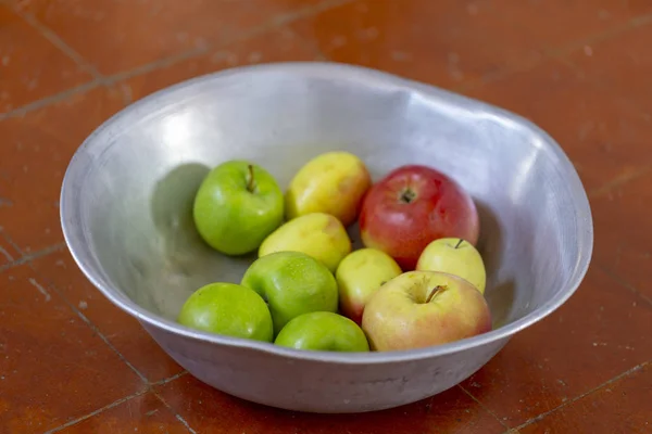 homemade apples from the garden in an enamel basin on the floor. your garden and harvest the apples. organic apples