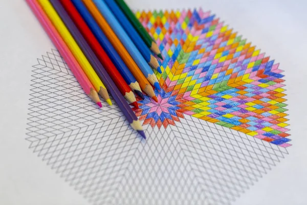 drawing mandala with colored pencils on a drawing template.