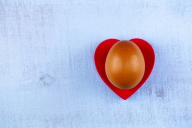 Easter eggs with heart decor on wooden background