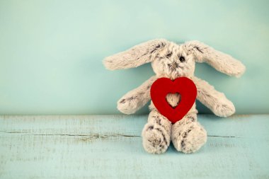 kalp mavi ahşap arka plan üzerinde gri pelüş tavşan