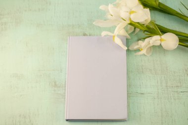 Not pad ahşap arka plan üzerinde beyaz canlı süsen