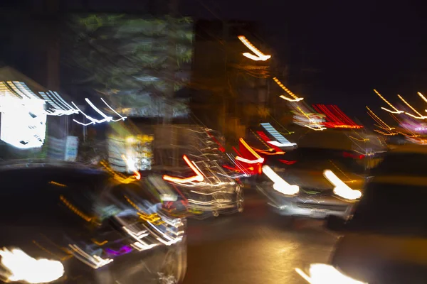 Нічний рух автомобілів в розмитому стані, світло від автомобілів і колби — стокове фото