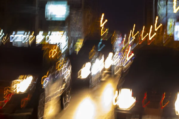 Нічний рух автомобілів в розмитому стані, світло від автомобілів і колби — стокове фото