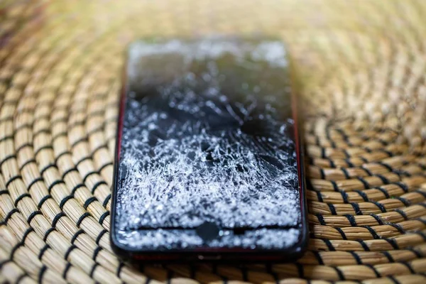 broken cell phone on a wooden surface