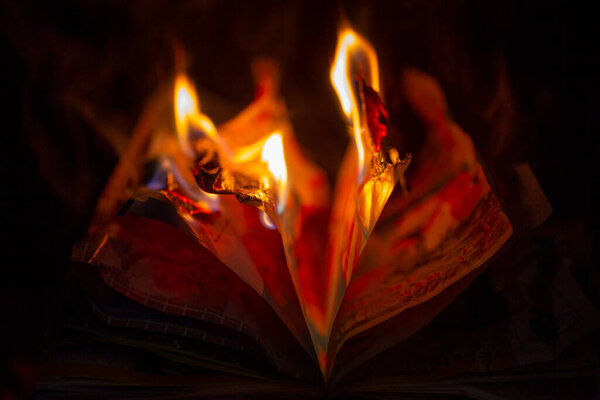 an old book burning in the fireplace, a fire in the fireplace
