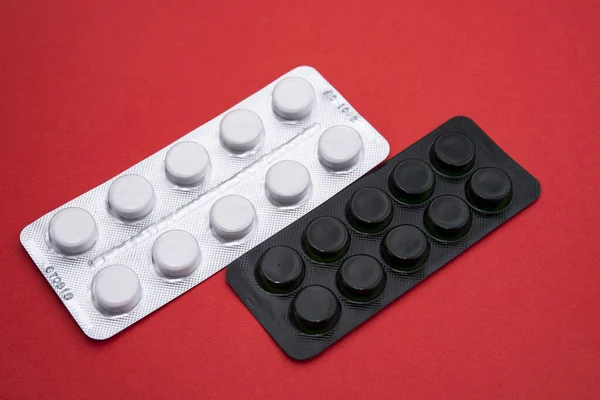 white pack of pills on red background, closeup horizontal