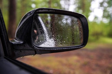 Bir araba dikiz aynasının su damlalarındaki fotoğrafı