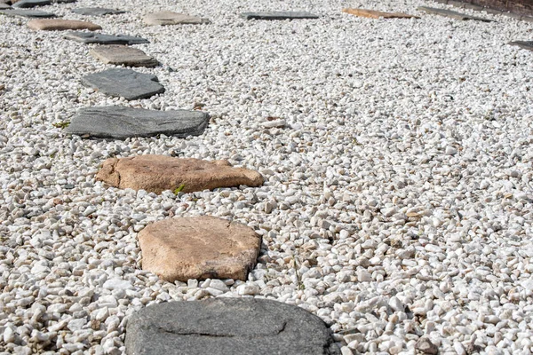 A stone path on a gravel backing in a Japanese garden. Stone path.