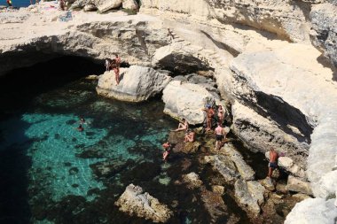 SALENTO, İtalya - 1 Haziran 2017 İnsanlar İtalya 'nın Salento Yarımadası, Roca' daki Grotta Della Poesia yüzme mağarasını ziyaret ediyor. Yıllık 50 milyon ziyaretçiyle İtalya, en çok ziyaret edilen ülkelerden biri oldu..