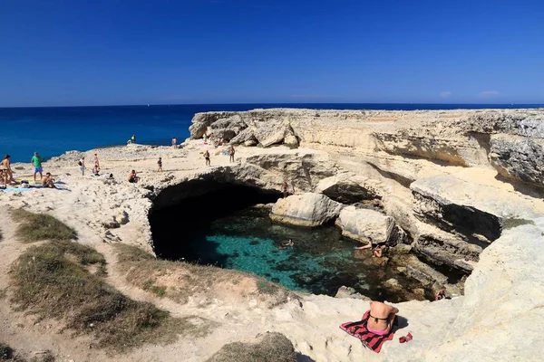 SALENTO, İtalya - 1 Haziran 2017 İnsanlar İtalya 'nın Salento Yarımadası, Roca' daki Grotta Della Poesia yüzme mağarasını ziyaret ediyor. Yıllık 50 milyon ziyaretçiyle İtalya, en çok ziyaret edilen ülkelerden biri oldu..