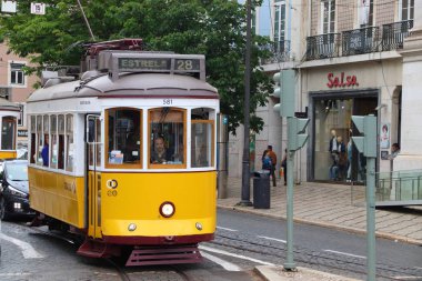 Lisbon, Portekiz - 6 Haziran 2018: İnsanlar sarı tramvay hattı 28 Chiado bölgesinde, Lizbon, Portekiz binmek. Lizbon tramvay ağ geri için 1873 tarihleri ve onun eski stil küçük tramvay için ünlüdür.