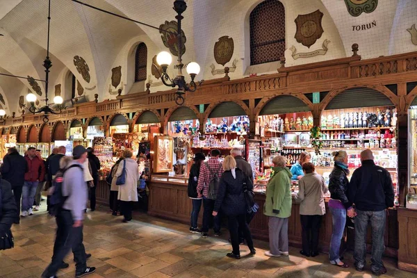 Krakow, Polonya - 12 Nisan 2014: satıcı satar Lehçe geleneksel el sanatları Hatıra Eşyası bez Salonu'nda, krakow. sukiennice bezi hall 1978 yılından bu yana unesco dünya mirası bir parçasıdır.
