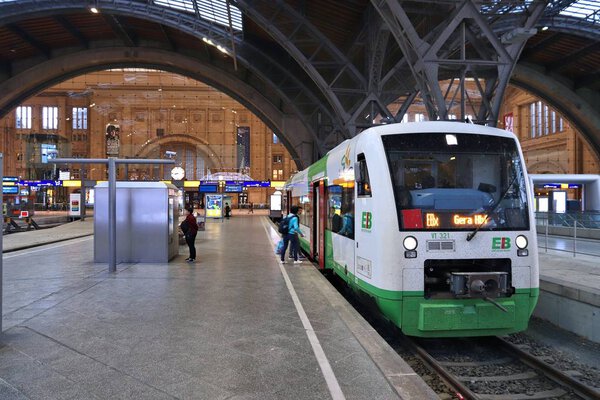 ЛЕЙПЦИГ, ГЕРМАНИЯ - 9 мая 2018 года: Люди садятся на поезд Erfurter Bahn на железнодорожном вокзале Лейпцига (Hauptbahnhof). На площади 83,460 квадратных метров, это самый большой железнодорожный вокзал по площади в мире
.