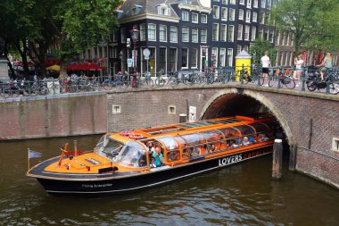 AMSTERDAM, NETHERLANDS - 10 Temmuz 2017: İnsanlar Hollanda, Amsterdam 'daki Herengracht Kanalı' nda bir gezi teknesine biniyorlar. Amsterdam Hollanda 'nın başkentidir..