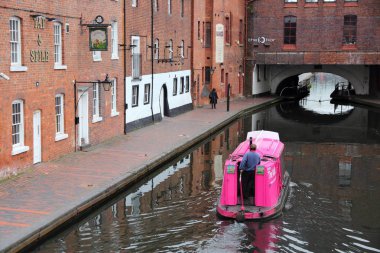 BIRMINGHAM, UK - APRIL 24, 2013: People ride a boat in the canal network in Birmingham, UK. Birmingham is the most populous British city outside London with 1.07 million residents.