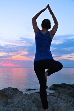 Yoga asana - sakin meditasyon İtalya kıyılarını günbatımı manzarası ile egzersiz. Vrikshasana - ağaç poz.