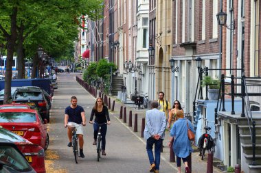 AMSTERDAM, NETHERLANDS - 8 Temmuz 2017: insanlar Amsterdam, Hollanda 'da bisiklet sürerler. Hollanda 'da 13 milyondan fazla bisiklet bulunmaktadır (16.5 milyon nüfusa sahip ülke).).