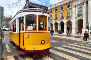 Lisbon, Portekiz - 4 Haziran 2018: İnsanlar Lizbon, Portekiz Praca Comercio meydanında sarı tramvay yolculuğu. Lizbon tramvay ağ geri için 1873 tarihleri ve onun eski stil küçük tramvay için ünlüdür.