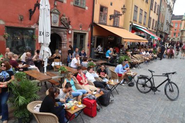Stockholm, İsveç - 23 Ağustos 2018: İnsanlar Gamla Stan (eski şehir) Stockholm, İsveç'te Stortorget kare kafede ziyaret edin. Başkenti ve en kalabalık alan İsveç Stokholm olduğunu.