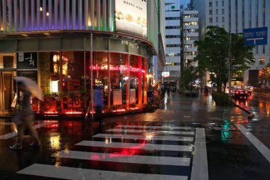 TOKYO, JAPONYA - 9 Mayıs 2012: Tokyo Shinjuku bölgesinde insanlar yağmurda alışveriş yapıyor. Shinjuku Tokyo 'nun özel koğuşlarından biridir. Burada 337,556 kişi yaşıyor..