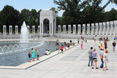 WASHINGTON, USA - JUNE 13, 2013: People visit National World War II Memorial in Washington DC. 18.9 million tourists visited capital of the United States in 2012. clipart