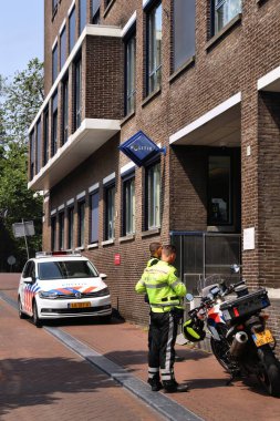 AMSTERDAM, NETHERLANDS - 7 Temmuz 2017: Hollanda, Amsterdam 'daki polis karakolunun önünde polis memurları. Polis (Politie) Hollanda 'da 63 binden fazla kişiye iş veriyor.