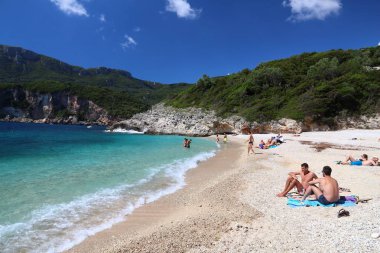 CORFU, GREECE - 2 Haziran 2016: İnsanlar Yunanistan 'ın Corfu Adası' ndaki Rovinia plajını ziyaret ediyor. 2012 yılında Korfu 'yu 558 bin turist ziyaret etti.