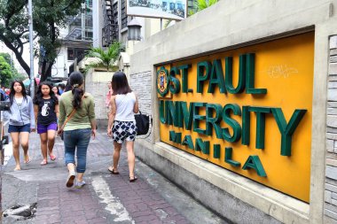 MANILA, PHILIPPINES - NOVEMBER 24, 2017: People walk by St. Paul University in Manila, Philippines. There are 2,300 colleges and universities in the Philippines. clipart