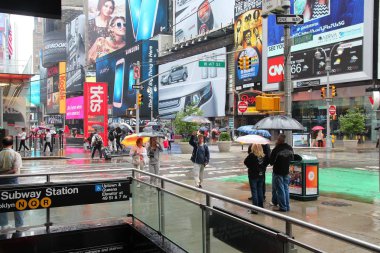 New York, ABD - 10 Haziran 2013: Yağmur altında Ny Times Square, insanlar yürüyüş. Times Meydanı dünyanın en tanınmış yerlerden biri. Times Meydanı'ndan her gün 300.000'den fazla kişi geçiş.