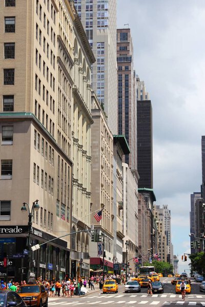 NEW YORK, USA - JULY 4, 2013: People walk along Fifth Avenue in New York. It is one of most expensive real estate areas in the world.