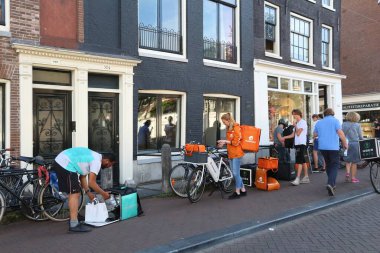 Amsterdam, Hollanda - 9 Temmuz 2017: Amsterdam, Hollanda içinde Uber yiyor, Thuisbezorgd ve Deliveroo gıda kuryeler bekleyin. Bisiklet gıda teslim Amsterdam'ın popüler.