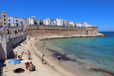 Monopoli, İtalya - 29 Mayıs 2017 İnsanlar İtalya 'nın Apulia kentindeki Monopoli plajını ziyaret ediyor. Yıllık 50 milyon ziyaretçiyle İtalya, en çok ziyaret edilen ülkelerden biri oldu..