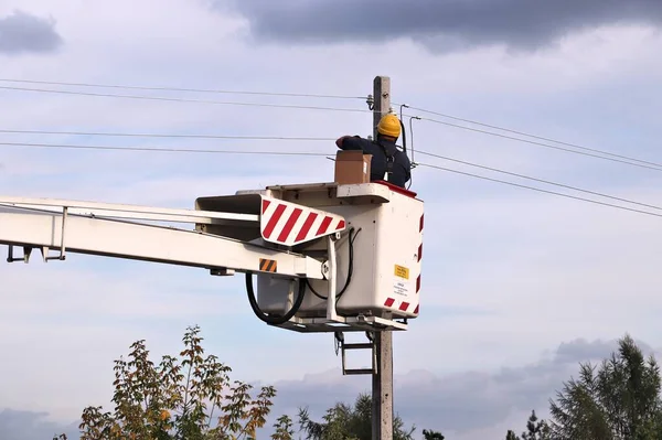 Electrician lineman in Europe. Electricity worker on a hydraulic lift in Poland.