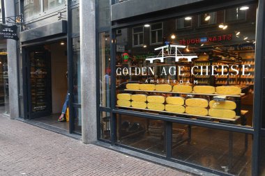 AMSTERDAM, NETHERLANDS - 9 Temmuz 2017: insanlar Amsterdam 'da bir peynir dükkanını ziyaret eder. Hollanda, gouda ve edam da dahil olmak üzere birden fazla sert peynir çeşidiyle ünlüdür..