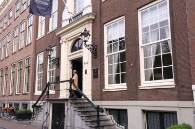 AMSTERDAM, NETHERLANDS - 10 Temmuz 2017: Waldorf Astoria Hotel kapıcısı Amsterdam, Hollanda 'da bekliyor. Waldorf-Astoria, Hilton Uluslararası Konukseverlik Grubu 'nun bir parçasıdır..