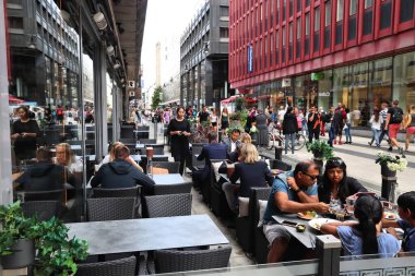 STOCKHOLM, SWEDEN - 23 Ağustos 2018: İnsanlar Norrmalm, Stockholm, İsveç 'teki Drottninggatan alışveriş caddesindeki restoranı ziyaret ediyorlar. Stockholm, İsveç 'in başkenti ve en kalabalık bölgesidir..