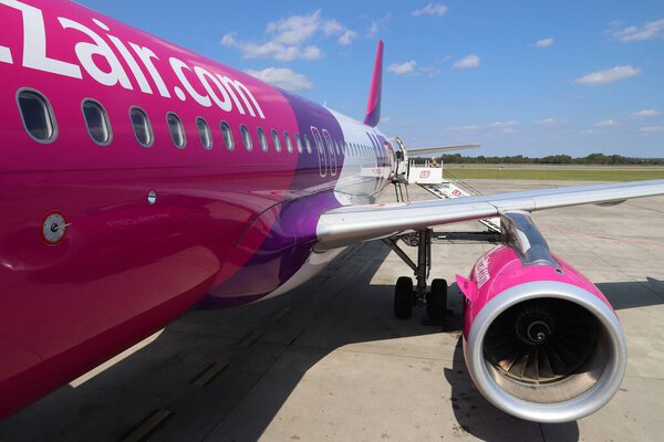 KATOWICE, POLAND - AUGUST 22, 2018: Пассажиры садятся на недорогие самолеты Wizz Air Airbus A320 в аэропорту Катовице в Польше. Катовице - четвертый по загруженности аэропорт в Польше (4,8 млн пассажиров в год).).
