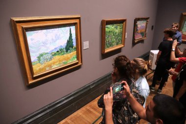 LONDON, İngiltere - 12 Temmuz 2019: Turistler Londra 'daki Ulusal Galeri' deki Van Gogh tablolarına hayran. Ülke, 5,7 milyon yıllık ziyaretçiyle İngiltere 'de en çok ziyaret edilen üçüncü müze olma özelliğini taşıyor..