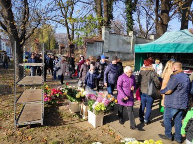 BYTOM, POLAND - 1 Kasım 2019: İnsanlar Polonya 'nın Bytom kentinde Azizler Günü (Lehçe: Dzien Wszystkich Swietych) sırasında çiçek ve mezar mumları satın alır.