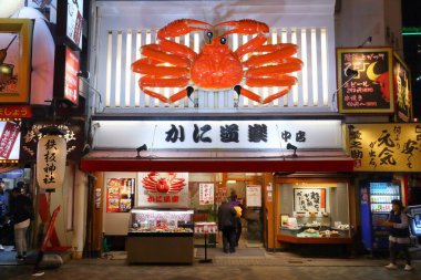OSAKA, Japonya - 21 Kasım 2016: İnsanlar Japonya 'nın Osaka kentindeki Dotonbori caddesindeki ünlü yengeç restoranını ziyaret ediyor. Dotonbori, Osaka 'nın ana eğlence alanıdır..