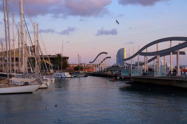 BARCELONA, İspanya - 6 Ekim 2021: İnsanlar İspanya 'nın Barcelona kentindeki Port Vell' deki Maremagnum alışveriş merkezi yakınlarındaki iskeleleri ziyaret ediyor.