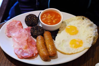 İrlanda kahvaltısı. Sosis, pastırma, puding, kızarmış yumurta ve fasulyeli geleneksel sabah yemeği..