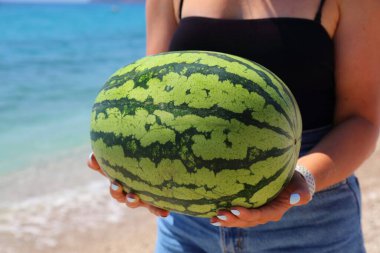 Yazın elinde kocaman bir Arnavut karpuzu tutan kadın..