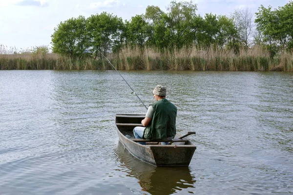 river fishing- man catching fish in boat