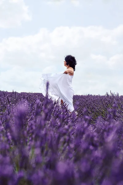 Celebrating the beauty of life- Beautiful happy pregnant woman on lavender fiel