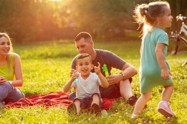 güneşli bir günde birlikte parkta genç aile aile zaman-Happy