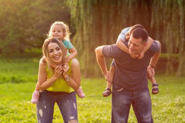 Aile çocuklarının omzunda ve parkta birlikte eğlenmek