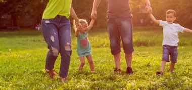 Çim parkta oynarken mutlu genç Aile